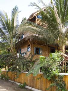 una casa con palmeras frente a una valla en Simply Paradise, en Mompiche