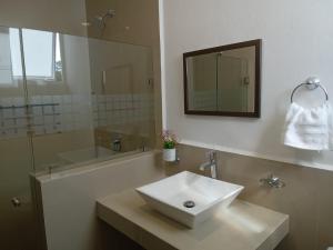 a bathroom with a white sink and a mirror at Villas Carlota Cancún in Cancún