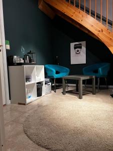 a living room with a table and blue chairs at Liten kjellerleilighet. Landlig rolig område. in Tromsø