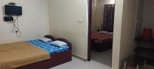 a small bedroom with two beds and a mirror at Guruvayur Adithya in Guruvāyūr