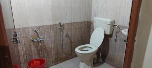 een badkamer met een toilet en een douche bij Guruvayur Adithya in Guruvāyūr