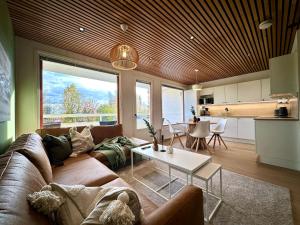a living room with a couch and a table at Kingwest Villa - free parking, sauna & 5 bedrooms in Tampere