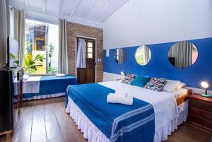um quarto azul e branco com uma cama e uma televisão em Pousada Recanto da Villa em Ilhabela