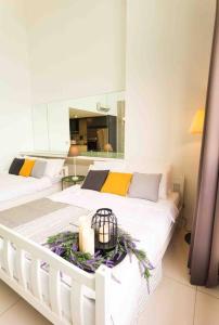 two beds in a white room with flowers and candles at [NEW LAUNCH] SUNRISE GURNEY SEAVIEW'63 无敌日出海景63 in George Town +45 photos