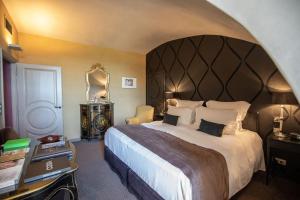 a bedroom with a large bed with a large headboard at Château de Mercuès in Mercuès