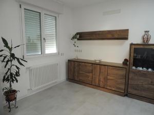 a living room with a wooden dresser and two windows at Casa Cortina in Domodossola +10 photos