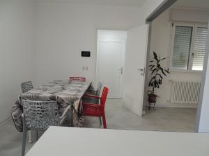 a dining room with a table and red chairs at Casa Cortina in Domodossola