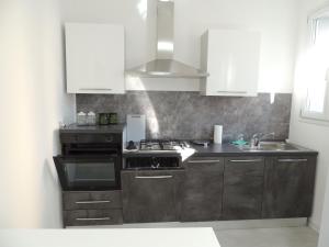 a kitchen with a stove and a sink at Casa Cortina in Domodossola