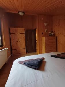 Un dormitorio con una cama con una toalla. en House in the Forest, en Cătunu