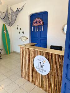 a surf shop with a blue door and a counter at Itzé Hostel Boutique - Progreso in Progreso