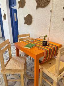 una mesa de madera con 2 sillas y una mesa con un libro en Itzé Hostel Boutique - Progreso, en Progreso