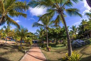 um caminho através de um parque com palmeiras em Pousada Cheiro de Mar em Nova Viçosa