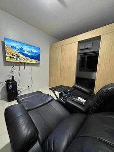 - un salon avec un canapé en cuir et une télévision à écran plat dans l'établissement SMDC Grass Residences - Unit # 2816, à Manille