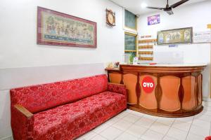 a waiting room with a red couch in a store at Hotel Upasana in Bhubaneshwar