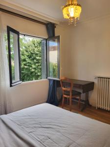 een slaapkamer met een bed, een bureau en ramen bij Maison à louer 3 chambres in Sartrouville