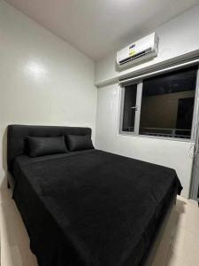- une chambre avec un lit noir et une fenêtre dans l'établissement SMDC Grass Residences - Unit # 2816, à Manille