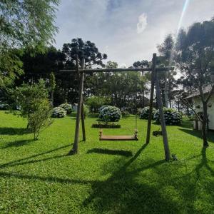 um parque com um baloiço na relva em Pousada Recanto Das Araucárias em Bocaina do Sul
