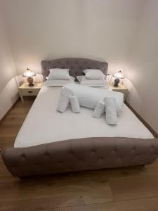 a large bed with white sheets and pillows on it at Apartament HERA in Alba Iulia