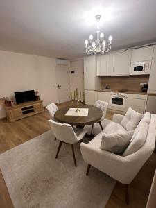 Il comprend un salon avec une table et des chaises ainsi qu'une cuisine. dans l'établissement Apartament HERA, à Alba Iulia