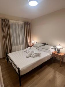 - une chambre avec un lit doté de draps blancs et une fenêtre dans l'établissement Apartament HERA, à Alba Iulia