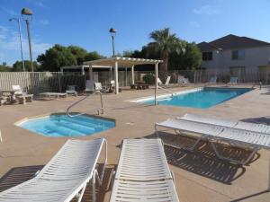 a group of lounge chairs and a swimming pool at Luxurious Condo at the Springs by Cool Properties in Mesquite