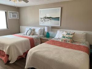 ニュー・スマーナ・ビーチにあるCoastal Waters 209のベッドルーム1室(ベッド2台付)が備わります。壁に絵が描かれています。