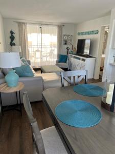 a living room with a couch and a table at Coastal Waters 209 in New Smyrna Beach