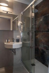 a bathroom with a sink and a glass shower at Katane Holidays in Catania
