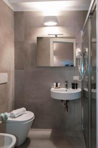 a bathroom with a sink and a toilet and a mirror at Katane Holidays in Catania +23 photos