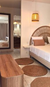 ein Schlafzimmer mit einem Bett und einem Tisch sowie ein Badezimmer in der Unterkunft Bohême Carib & Massage - Un Goût De Paradis ! in Deshaies