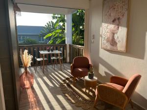 a living room with a balcony with chairs and a table at Studio La Normantillaise in Petit-Bourg