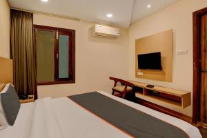 a hotel room with a bed and a flat screen tv at Collection O Hotel Orange Regency in Dehradun