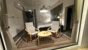 Zimmer mit 2 Stühlen, einem Tisch und einem Bett in der Unterkunft Dune Chalet شالية ديون in Al Wāşil
