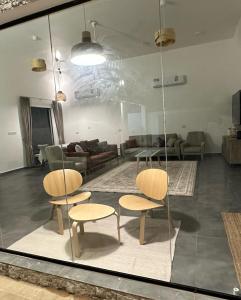ein Wohnzimmer mit 2 Stühlen und einem Sofa in der Unterkunft Dune Chalet شالية ديون in Al Wāşil