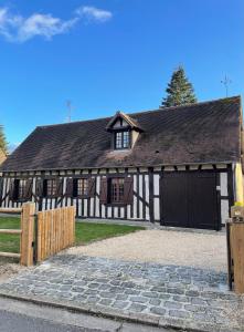 een groot zwart-wit gebouw met een garage bij La demeure du Cerf gîte de charme privatif 6P en Sologne Jacuzzi Piscine chauffée sud Orléans Beauval in Chaon