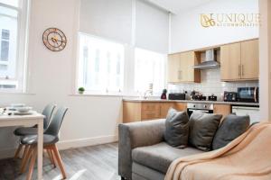 a living room with a couch and a kitchen at Luxury 2-bed Haven in Liverpool in Liverpool