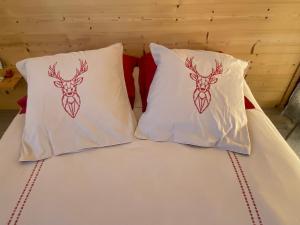 dwie poduszki z głowami jeleni na łóżku w obiekcie Chambre de la Tournette w mieście Saint-Jorioz