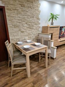 einen Esstisch mit Stühlen und eine Steinmauer in der Unterkunft Apartmán Siesta in Poprad