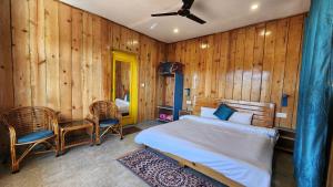 1 dormitorio con 1 cama y 2 sillas en Neelkanth Retreat Mukteshwar, en Mukteshwar