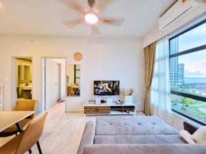 a living room with a couch and a large window at #9 Jesselton Quay City Pads Seaview by Zeluxo in Kota Kinabalu