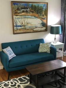- un salon avec un canapé bleu et une table dans l'établissement Beautiful Multi-Generational Country Home, à Corning
