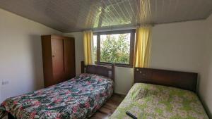 1 dormitorio con 2 camas y ventana en Apartamento Santa Barbara, en Sáchica