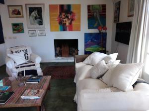 uma sala de estar com dois sofás brancos e uma mesa de centro em Casa con piscina a 5 minutos del centro em El Challao