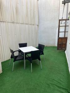una mesa y sillas en una habitación con alfombra verde en Aires de gredos/bajo, en Candeleda
