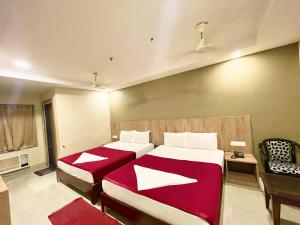 Hotel Janaki Pride, Puri fully-air-conditioned-hotel spacious-room with-lift-and-parking-facility في بوري: غرفة فندقية بسريرين ومكتب