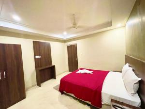 a bedroom with a bed with a red blanket at Hotel Janaki Pride, Puri fully-air-conditioned-hotel spacious-room with-lift-and-parking-facility in Puri
