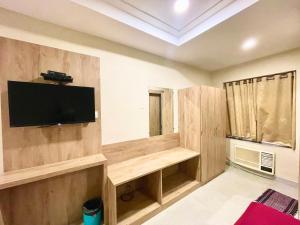 a living room with a flat screen tv on the wall at Hotel Janaki Pride, Puri fully-air-conditioned-hotel spacious-room with-lift-and-parking-facility in Puri