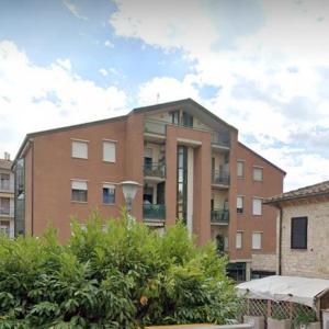 un gran edificio de ladrillo con arbustos delante de él en Casa di Giulia, en Perugia