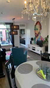 a living room with a table and a painting on the wall at Cityhouse Vincent in Den Helder