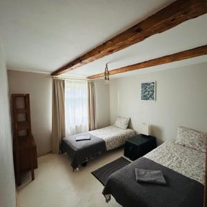 1 dormitorio con 2 camas y ventana en WILLOW en Pāvilosta